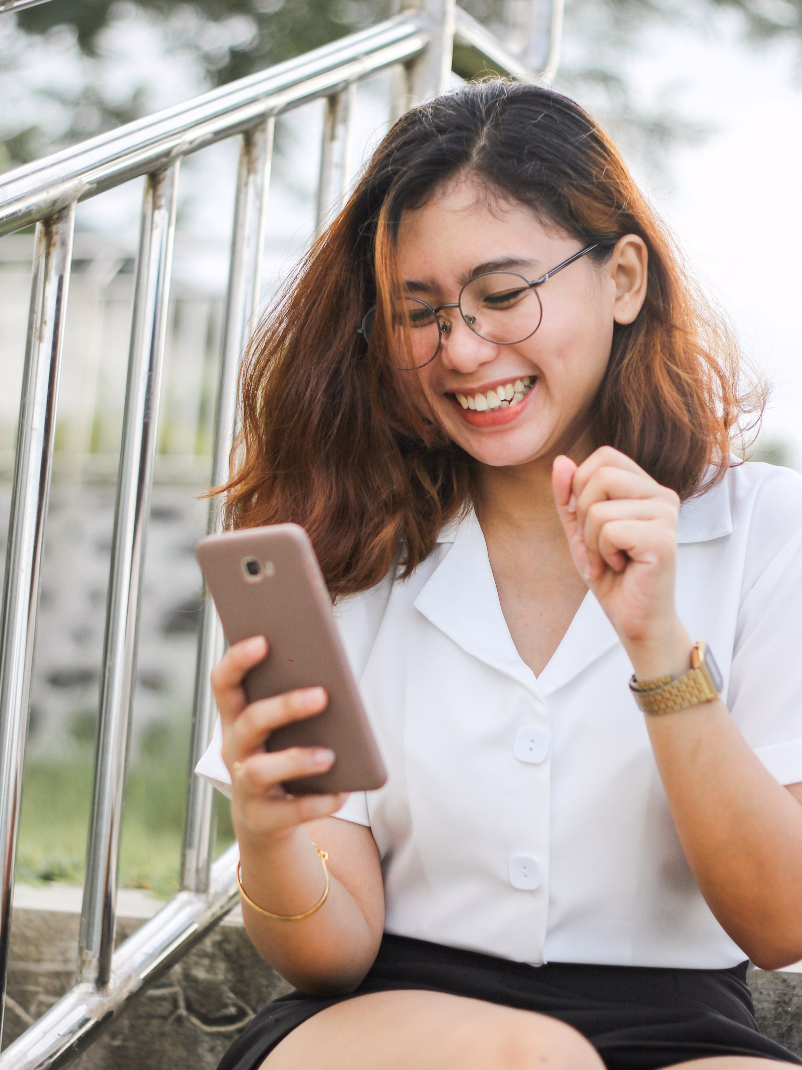 Woman laughing at her phone while reading a message